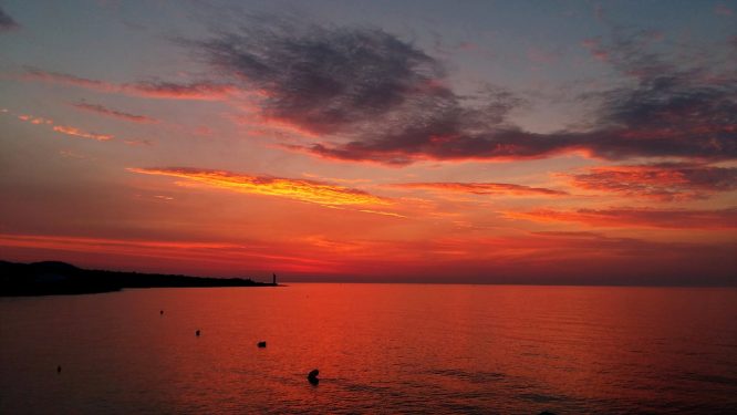 a red sunrise sky over water